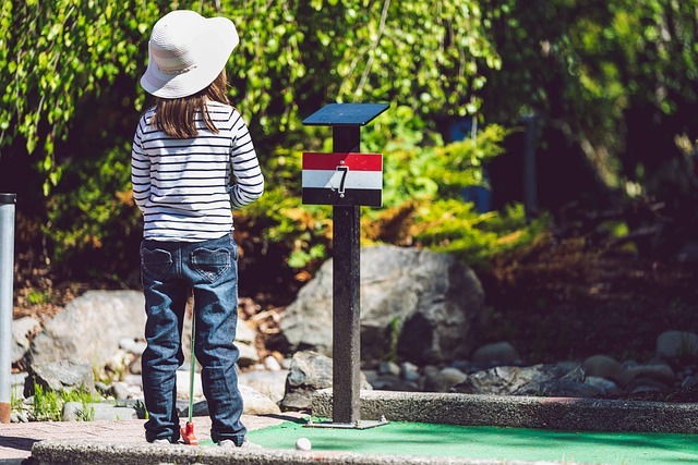 Enfants jouant au mini-golf près de Morillon sous un ciel variable, activité familiale simple quand la météo hésite.
